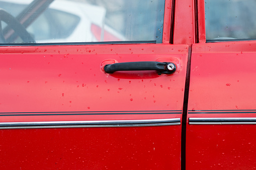 Closeup of door handle of red retro classic car