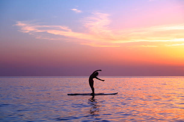 istock Yoga trainer over sunset background 688053782
