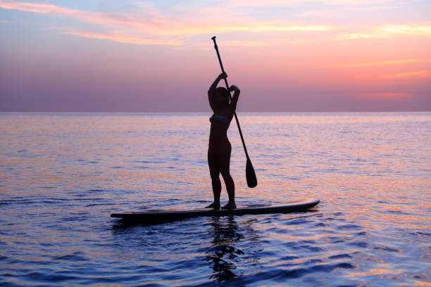 istock Silhouette of a girl practicing SUP 688054024