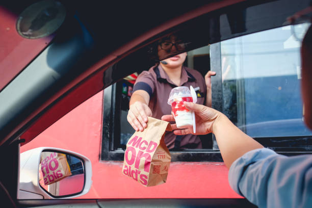 bangkok, tajlandia - 4 marca 2017: klient otrzymujący hamburgera i lody po zamówieniu i kup go w mcdonald's drive thru service - editorial asia thailand people zdjęcia i obrazy z banku zdjęć