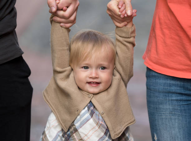 istock Parents holding daughter by the hands 688057784