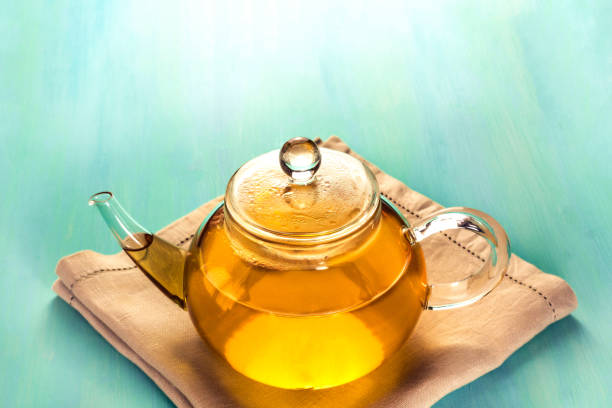 istock Teapot full of tea on teal texture with copyspace 688060160