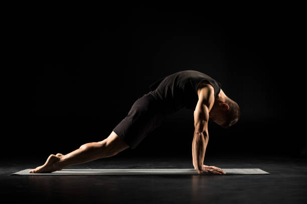 Man standing in yoga position Man practicing yoga performing asana marjariasana on yoga mat cat pose yoga stock pictures, royalty-free photos & images