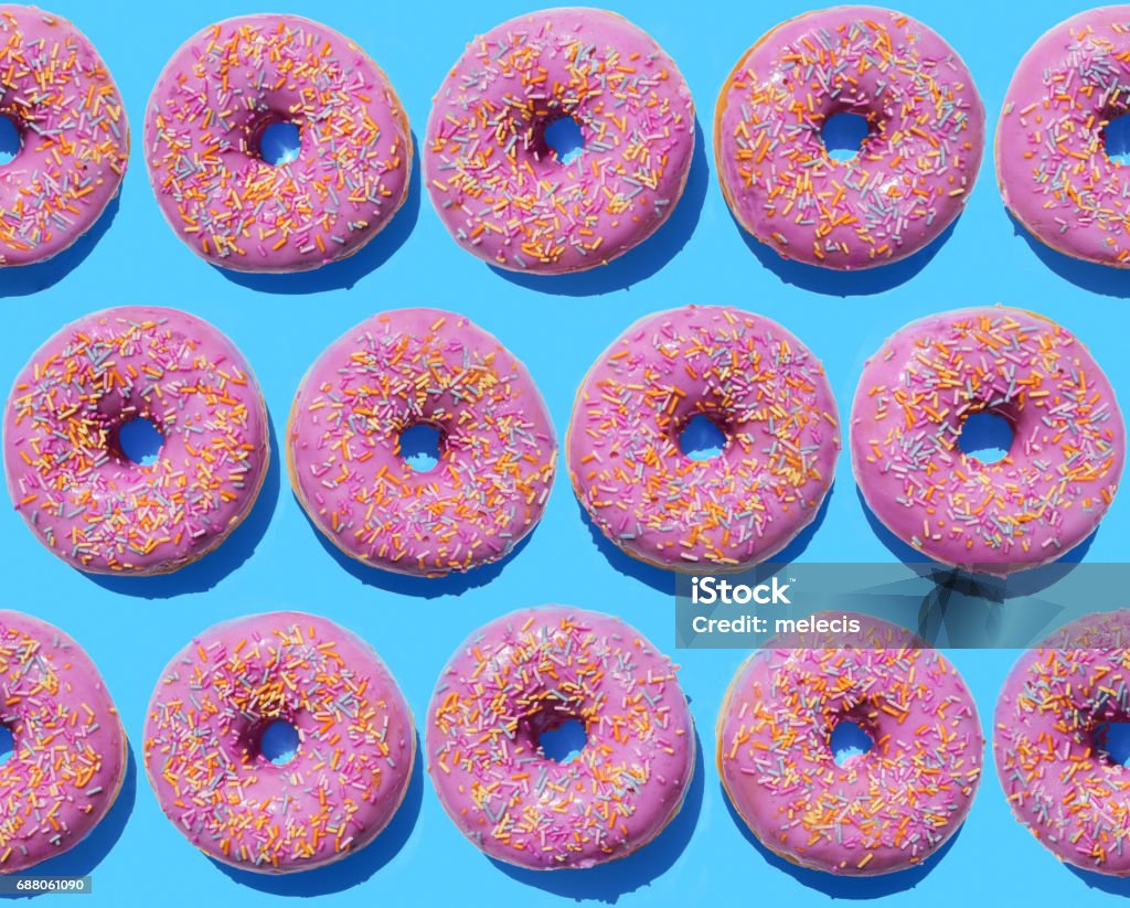 Pink ring doughnuts on blue background Seamless pattern, background, dessert, Pattern Stock Photo