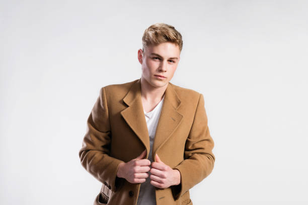 istock Young handsome hipster man in brown coat, studio shot. 688067380