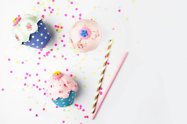 istock White background with party accessories. Invitation mockup. Confetti and muffins. cake. Flat lay 688075952