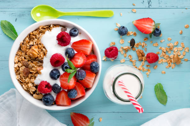desayuno de granola con bayas - yogurt yogurt container strawberry spoon fotografías e imágenes de stock