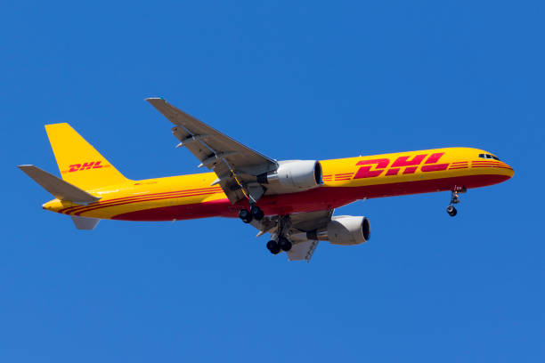 dhl 757 on a clear blue sky - dhl airplane freight transportation boeing imagens e fotografias de stock