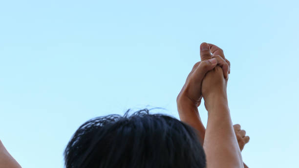 istock holding hands of people in the sky, copy space on left 688089464