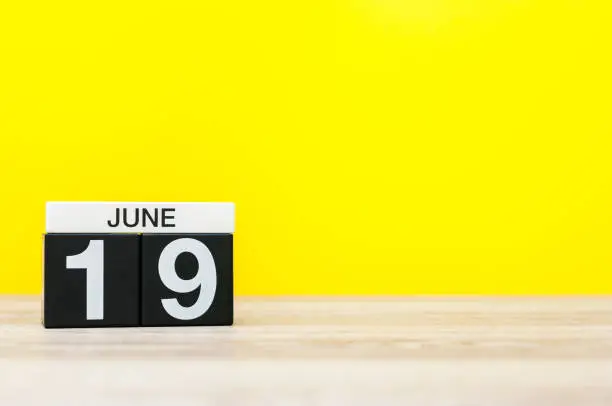 June 19th. Day 19 of month, calendar on yellow background. Summer day. Empty space for text.