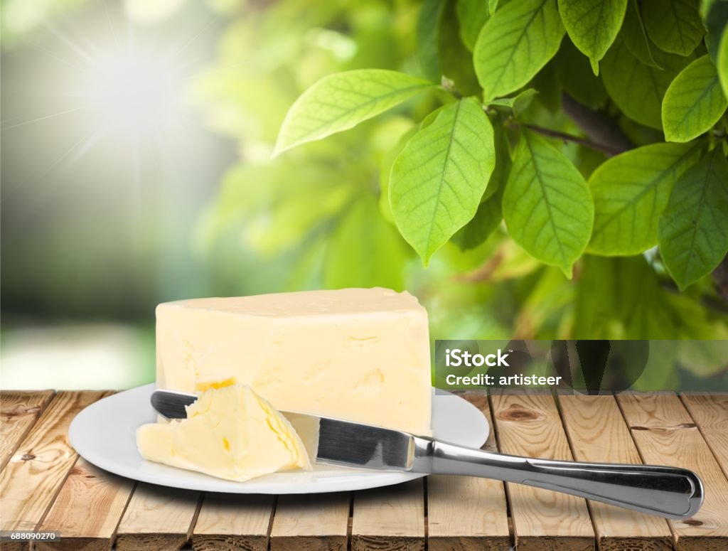 Butter. Pat of fresh farm butter on a butter dish with a knife on backgrouund Baking Stock Photo
