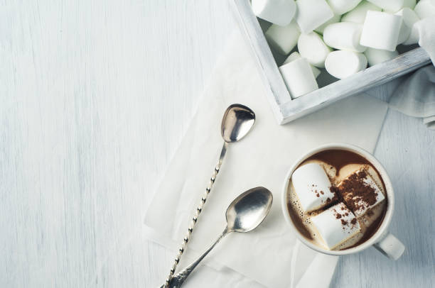 istock White coffee Cup and marshmallows in a wooden box over a white background 688095478