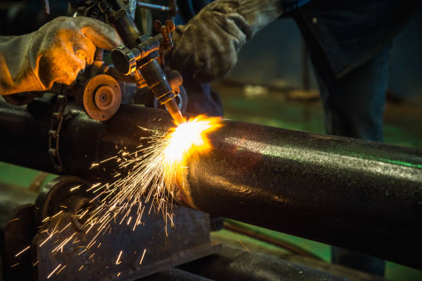 istock Acetylene torch cutting tube industrial for construction fabrication with bright sparks in steel factory. 688098498