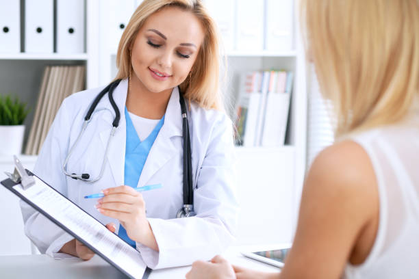 istock Doctor and  patient  discussing something while phisician pointing into medical history form at clipboard 688116642