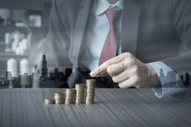 istock Double exposure business man putting money coins stack growing, saving money concept 688117556