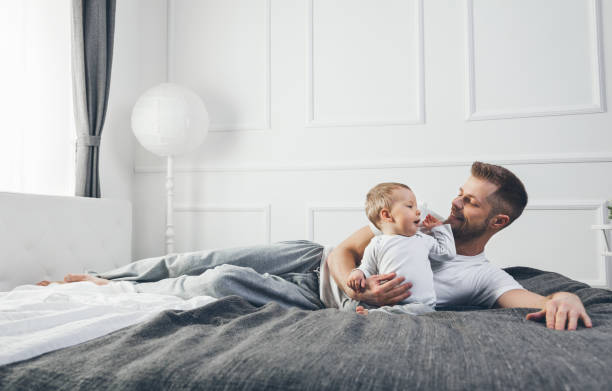 istock Happy father with his son playing at home on the bed 688120750