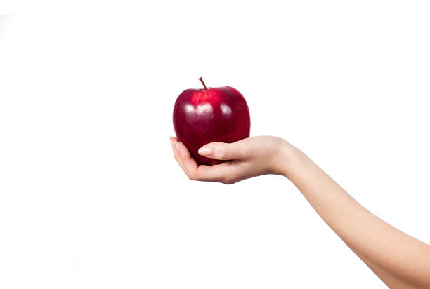 istock Woman's hand holding and showing a  apple on white background 688140600