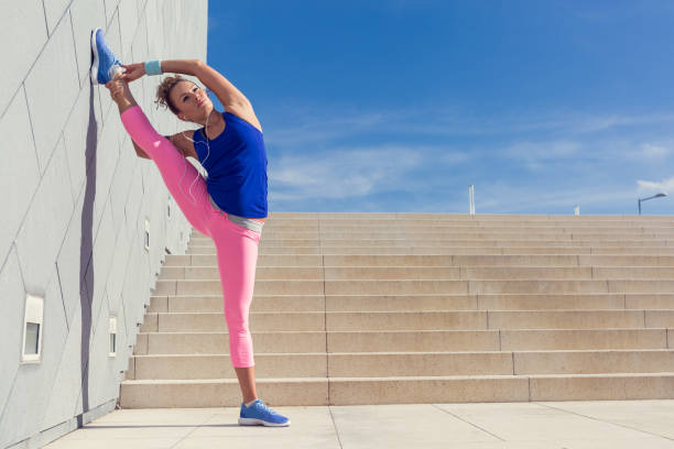 istock Young woman stretching before workout against surrounding wall 688144250