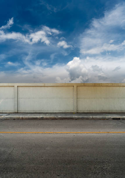 istock Asphalt road and concrete fence with blue sky 688144280