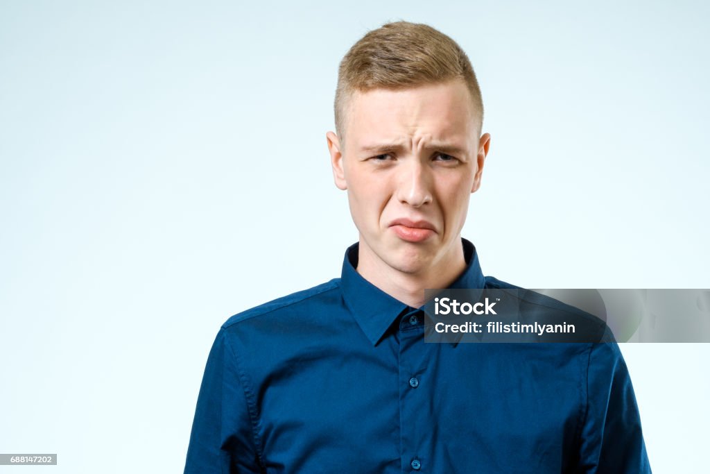 Sad upset young man over white background Disgust Stock Photo