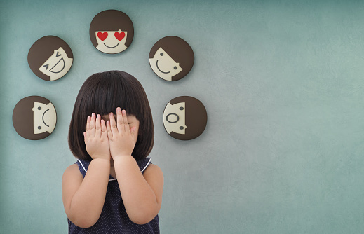 Muchacha del niño Asiático con fondo verde muro de hormigón, sentimientos y emociones del niño photo