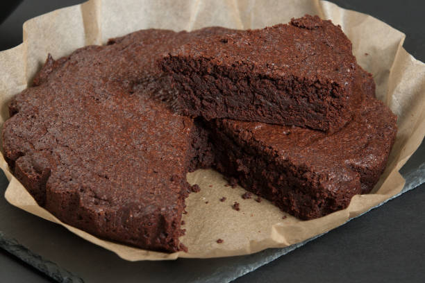selbstgemachte schokolade brownie in pergamentpapier. schiefer. - brownie baked bakery brown stock-fotos und bilder