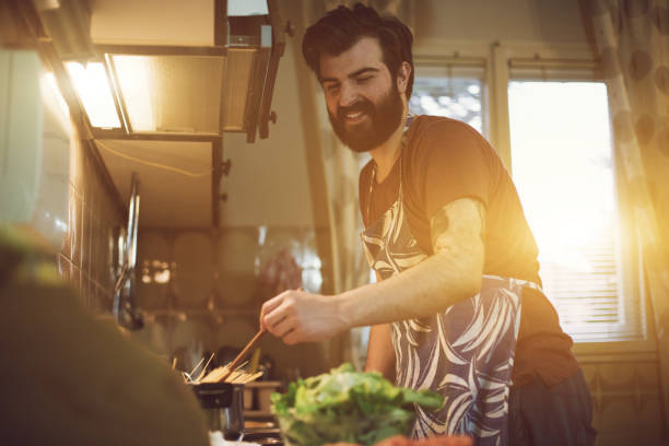 istock Handsome bearded man preparing food in the kitchen 688157282