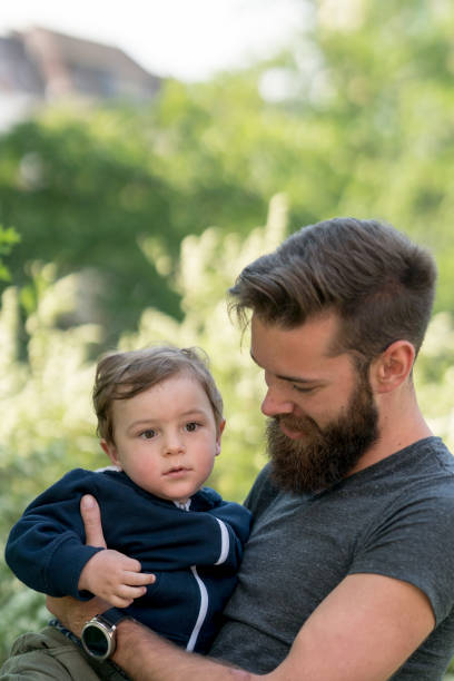 istock Young hipster father holding his little son in park 688157912