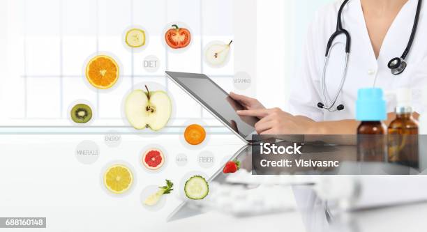 Healthy Food Supplements Concept Hand Of Nutritionist Doctor Touch Digital Tablet On Symbols Fruits Background Stock Photo - Download Image Now