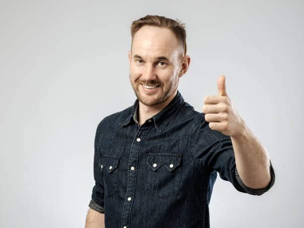 istock Happy young handsome man gesturing isolated on gray background 688160654