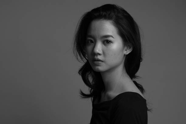 Beautiful but depressed asian in black and white stock photo