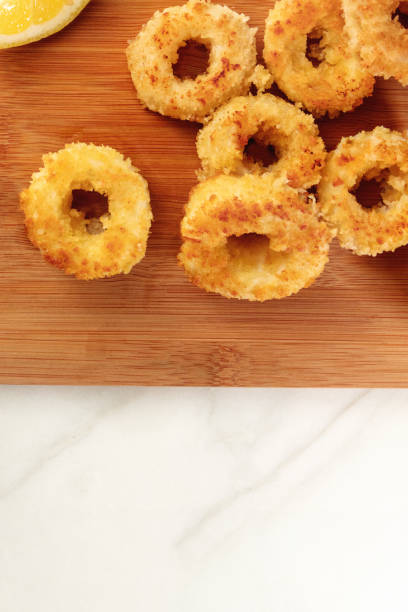istock Closeup of fried calamari rings with lemon and copyspace 688164734