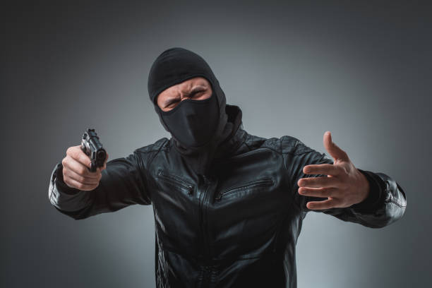 istock Masked robber with gun, looking into the camera 688167412