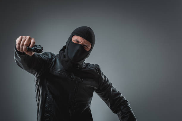 istock Masked robber with gun, looking into the camera 688168440