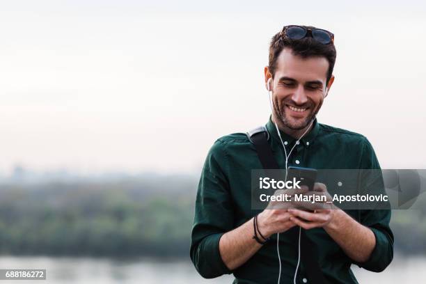 Young Man Listening To The Music Stock Photo - Download Image Now - Smart Phone, Listening, Music