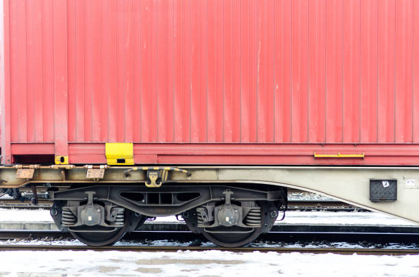 Train wagon. Part of train wagon with red cargo container on railway.
