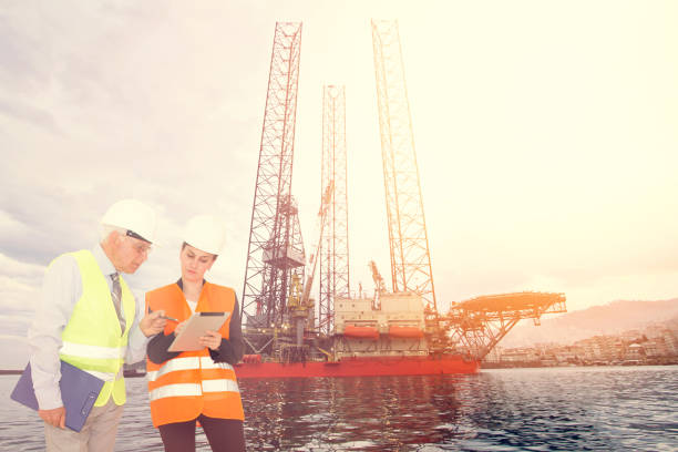 istock Attractive young female engineer and her boss, Offshore construction platform 688210704