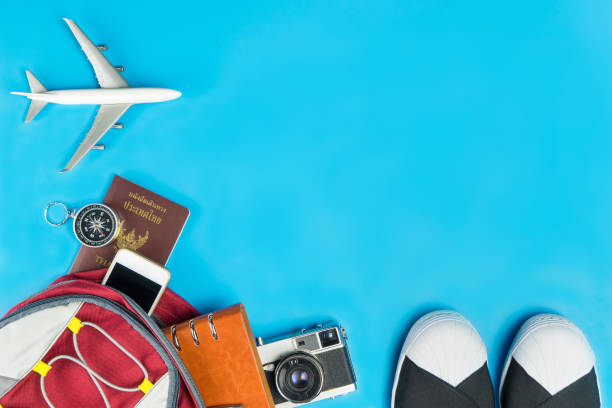 istock Backpacker travel accessories with toy plane on blue background 688211664