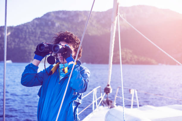 istock Young woman sailing, looking with binoculars 688239106