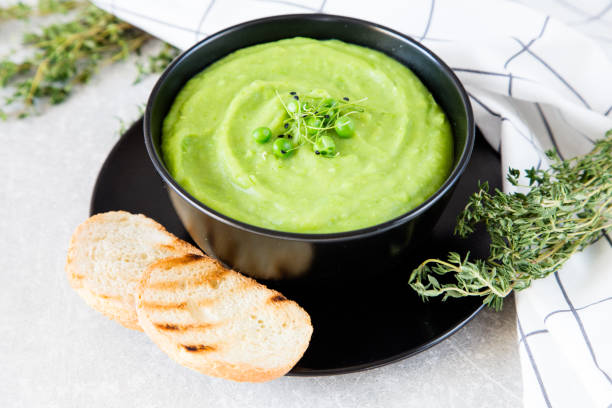 istock Homemade puree soup with green peas and micro greens. selective focus 688248668