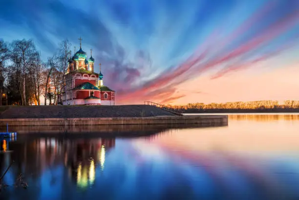 The Church of Dmitry on the blood with the reflection in the Volga and blue and pink clouds of spring sunset in Uglich