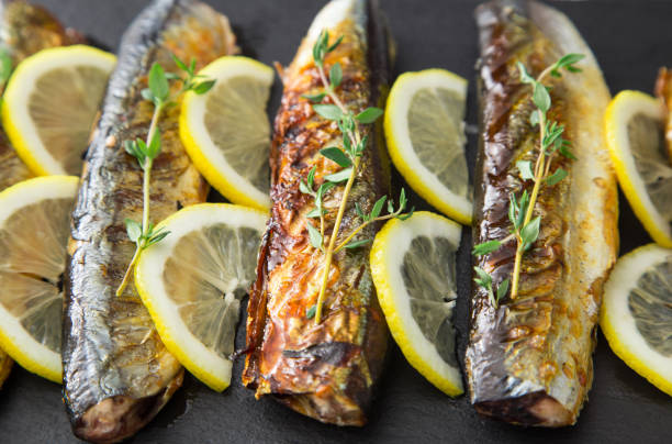 istock grilled fish saury with lemon on a slate Board 688255874