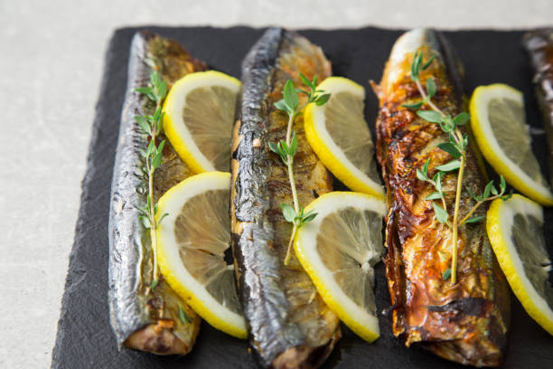 istock grilled fish saury with lemon on a slate Board 688256286