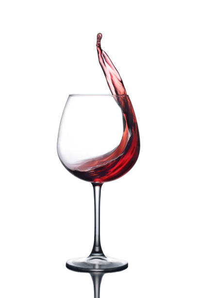istock Splash of red wine in a glass on a white background with reflection 688271136