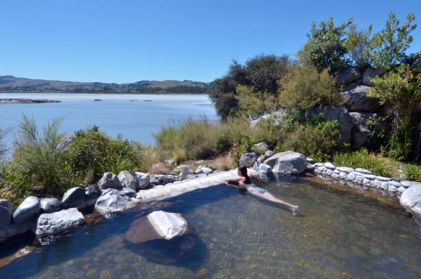 Young woman having a spa in outdoors hot pool in Rotorua, New Zealand.