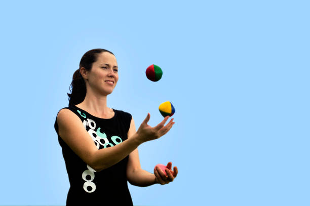 Young woman juggler is juggling balls.