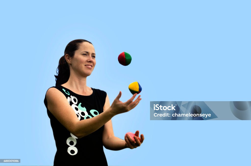 Woman Juggling Balls Young woman juggler is juggling balls. Juggling Stock Photo