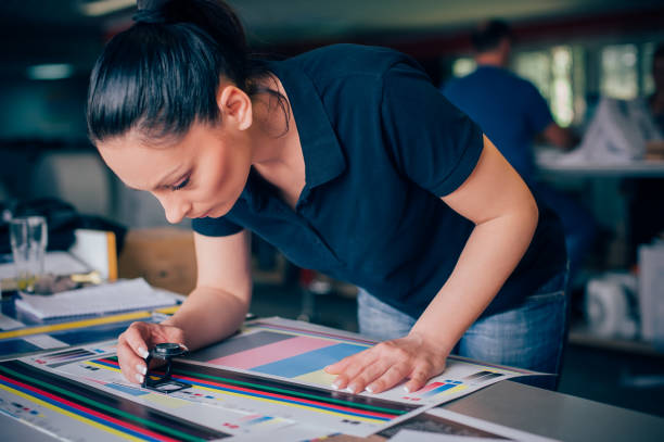 jeune femme travaillant à l'usine d'impression - print shop photos et images de collection