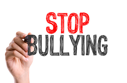 Hand with marker writing the word Stop Bullying