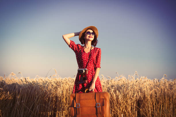 istock young woman with camera and suitcase 688307818